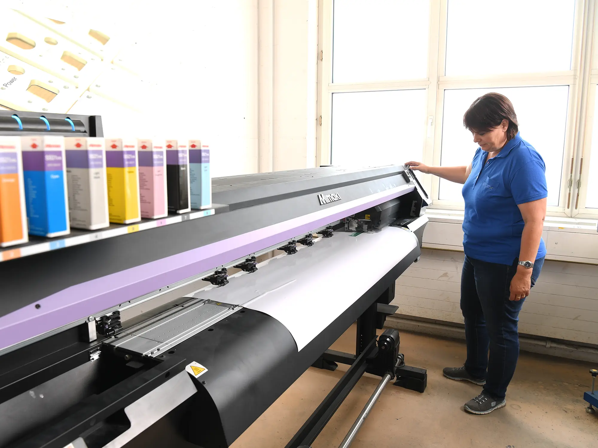 Mitarbeiterin vor Plotter